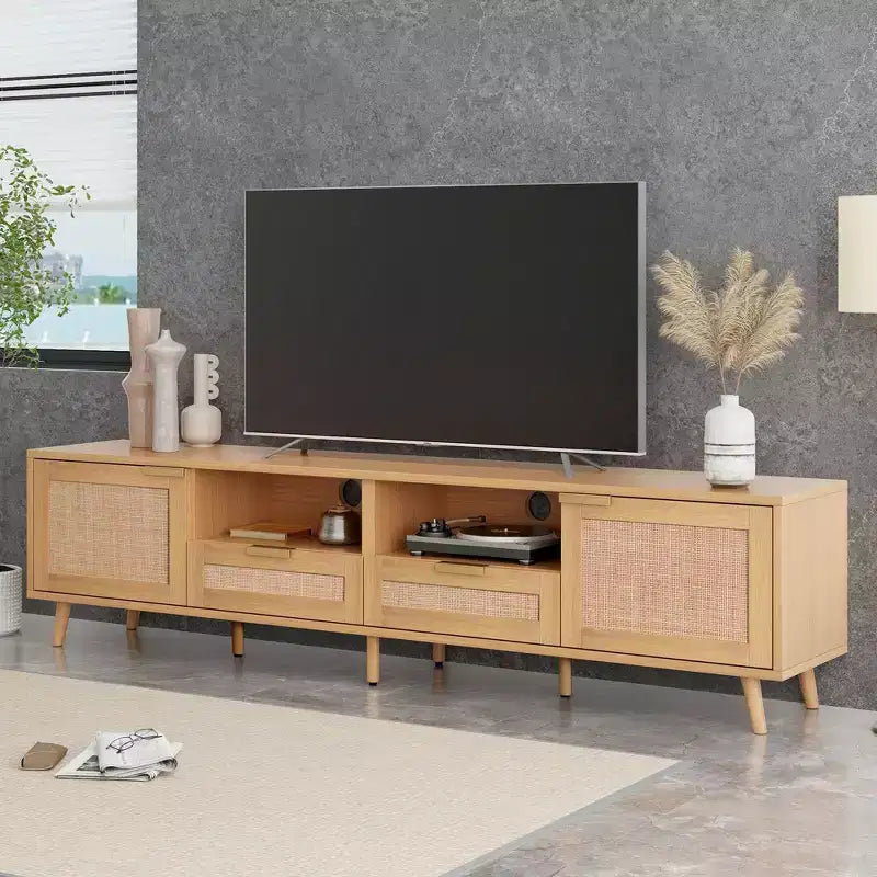 Meuble TV moderne en rotin avec étagères ouvertes et pieds en bois robustes.